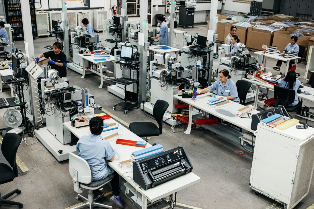 Workers in a manufacturing facility pack finished credit cards into boxes at CPI Card Group.