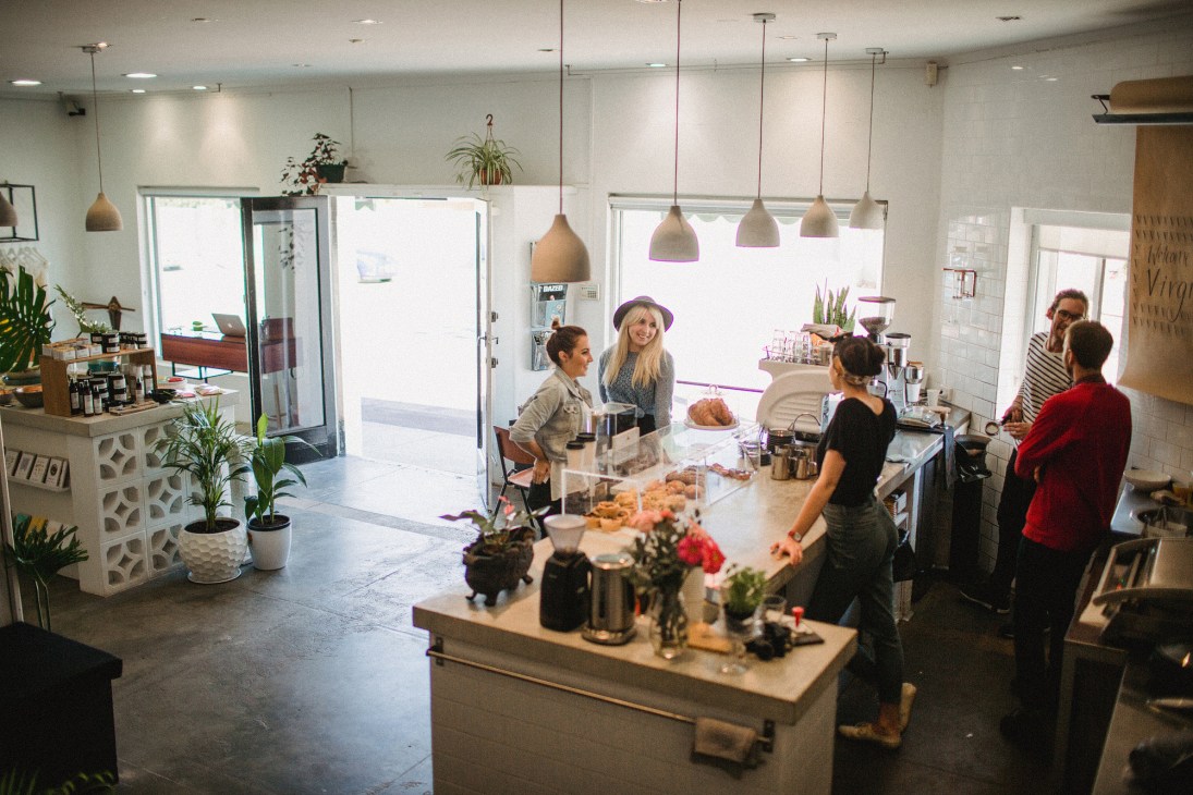 Interior of Virgil Coffee café at 324 Oxford with customers at counter and pendant lighting.