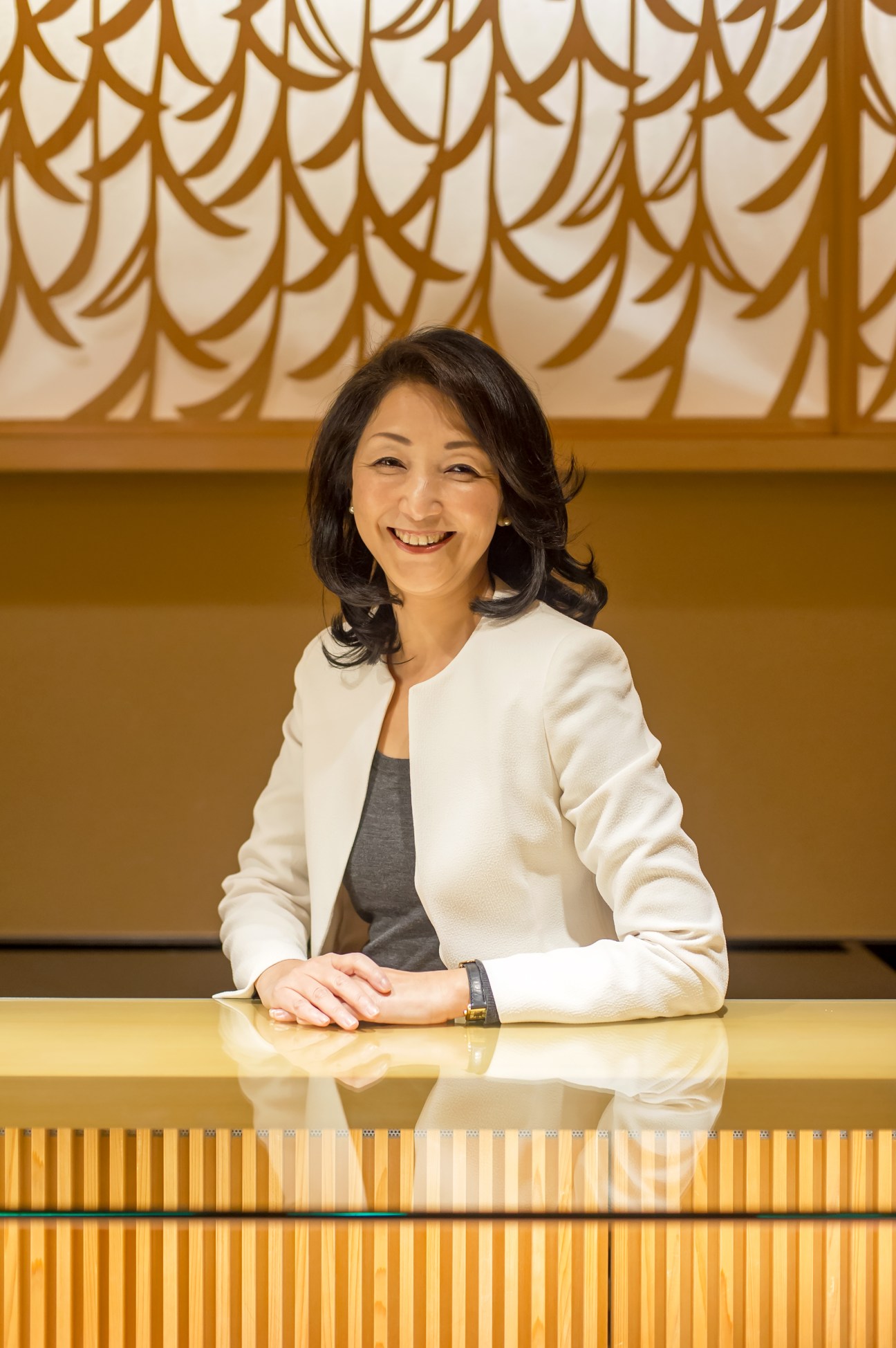 Kayo Hosono, president of Akebono, smiling at a table in the original Ginza shop.