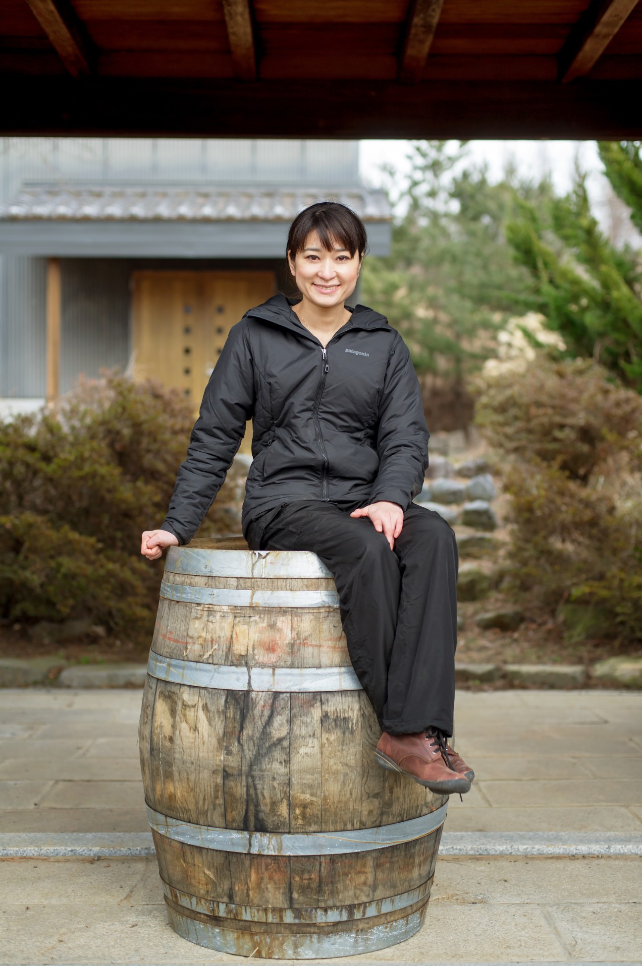 Ayana Misawa, head winemaker at Grace Winery, sits on a wooden wine barrel at the winery estate.