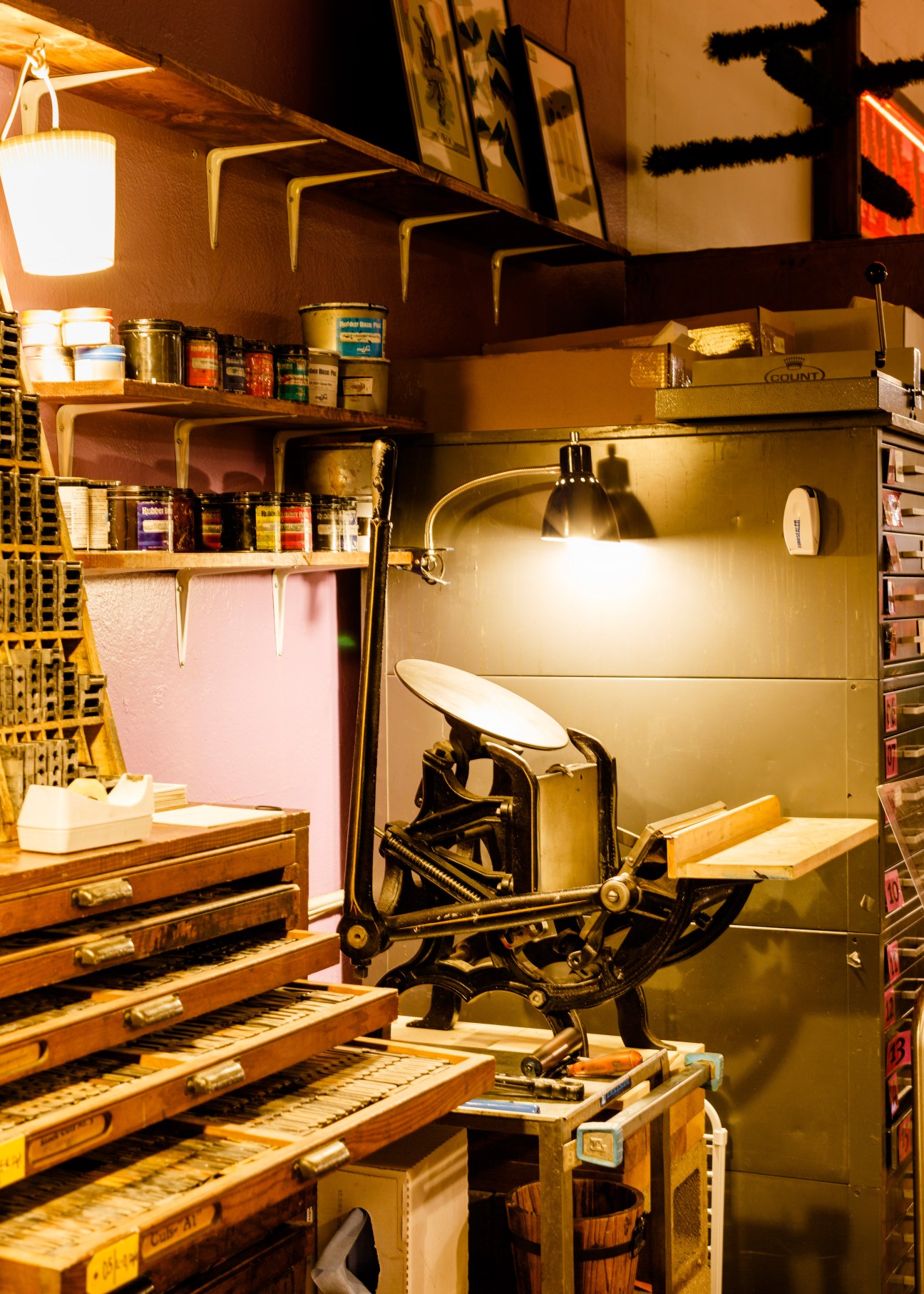 Interior of We Are 1976 shop displaying ceramics, stationery, and printing equipment on wooden shelves.