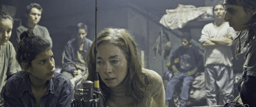 Scene from the film Monos showing young militia members in a dimly lit interior setting.