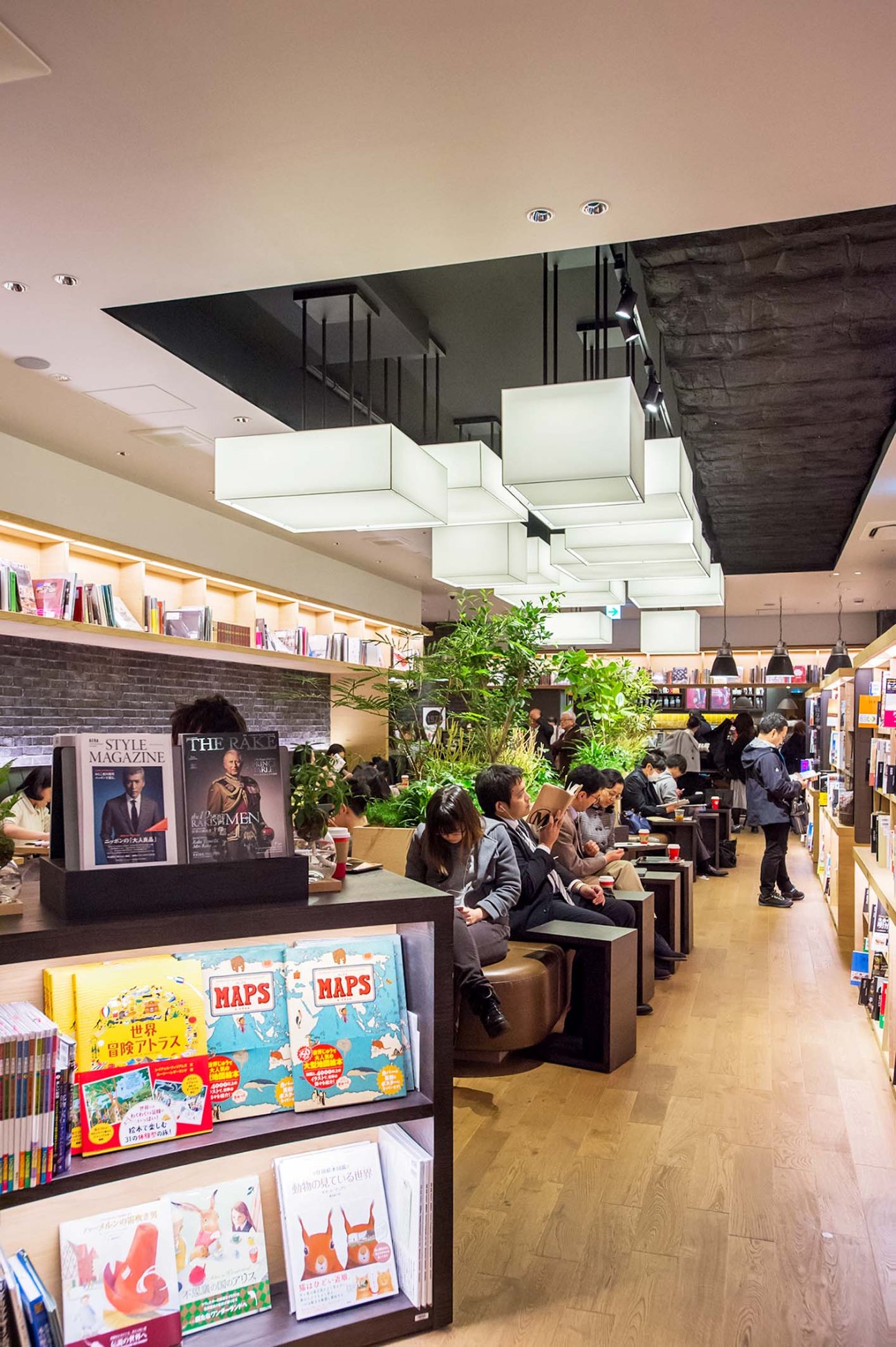 Interior of Urawa Tsutaya Books bookshop in Tokyo with customers browsing shelves, seating areas, and modern lighting.
