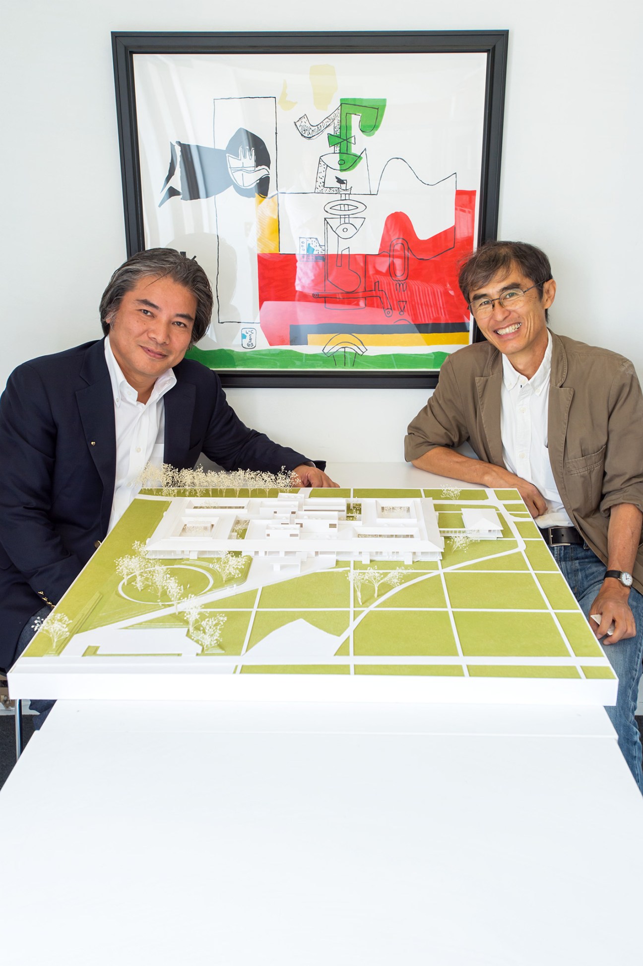 Architects Hikoshiro Goya and Yoshinari Shiota with a site plan model of Ebino Ryofuen nursing home.