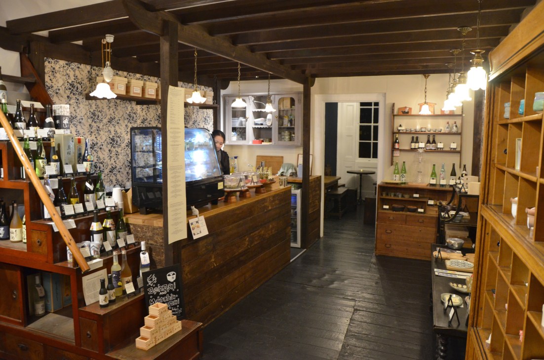 Interior of Katsute 100 Japanese tea room in London with shelves of tea and moody lighting