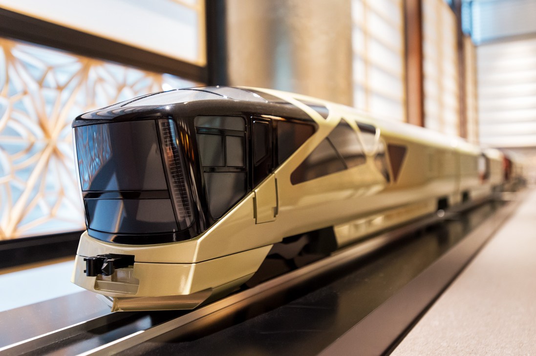 Model of East Japan Railway's Shiki-Shima Train Suite, a gold and black luxury train design on display.