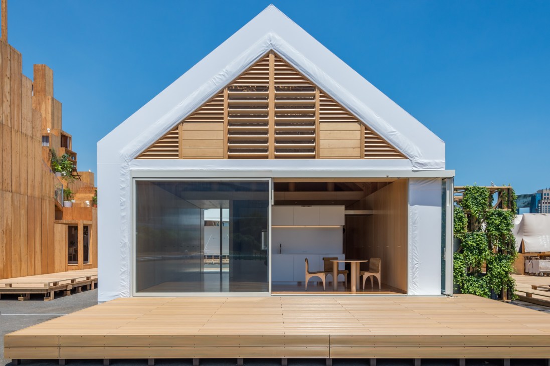 Life Core house with white gable end, large glass sliding doors, wooden deck, and louvered upper window detail.