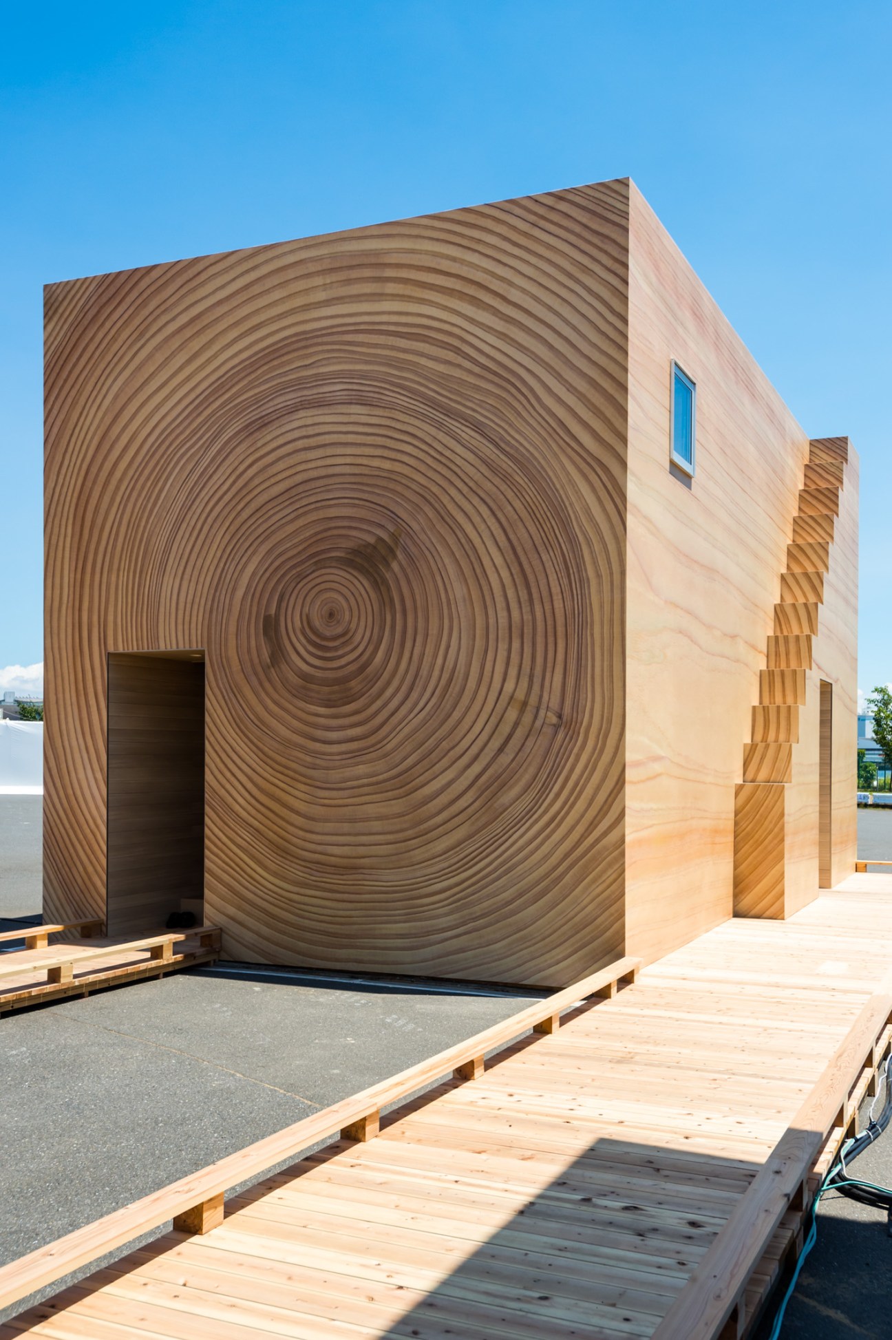 Woodgrain House with printed wood-grain exterior and blue window detail designed by Kenya Hara and Toppan Printing.
