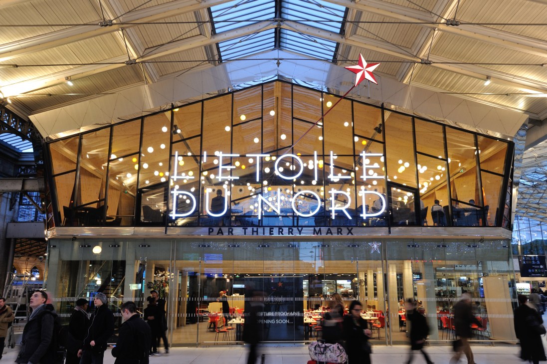 L'Etoile du Nord restaurant storefront at Gare du Nord in Paris with neon signage and glass facade.