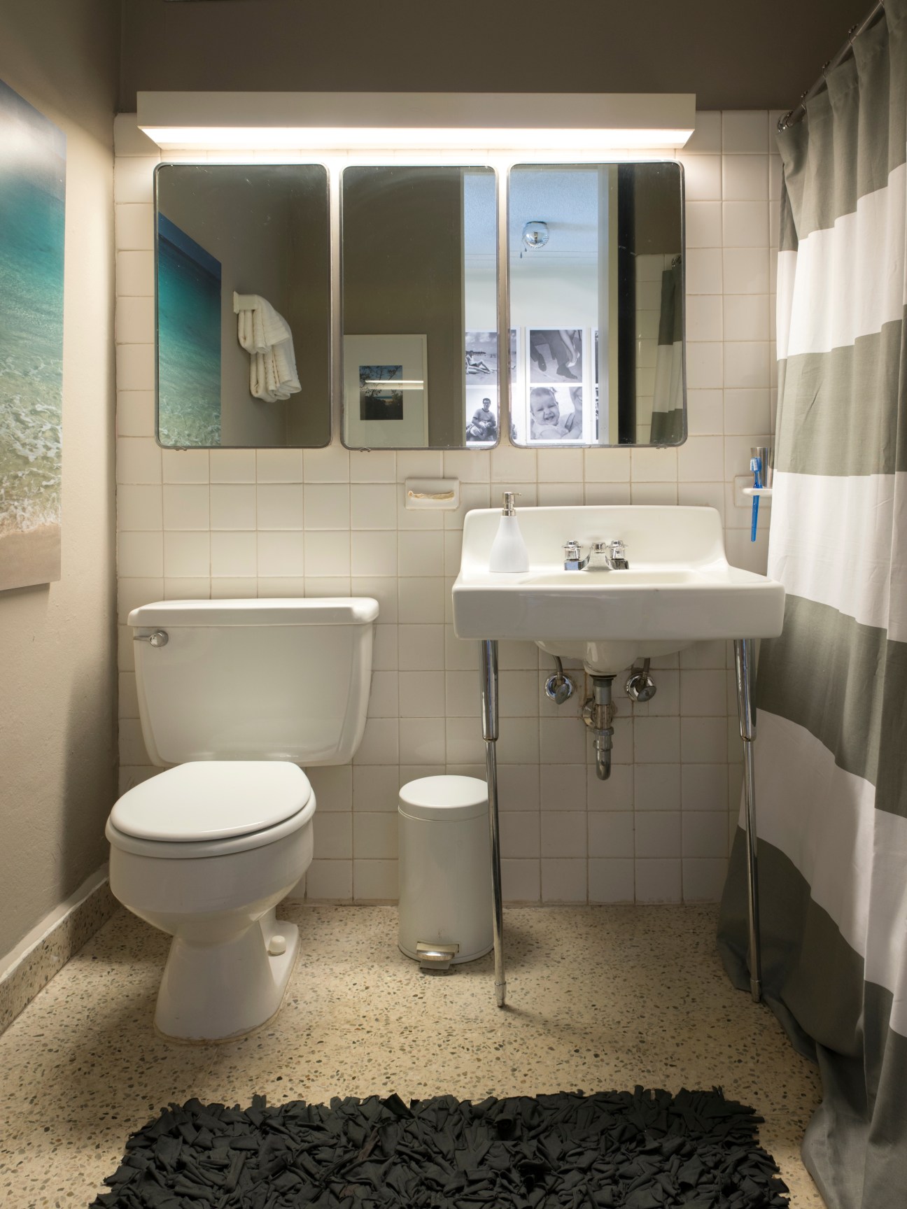 Mid-century bathroom with retro fixtures, terrazzo flooring, and original wall tiles.