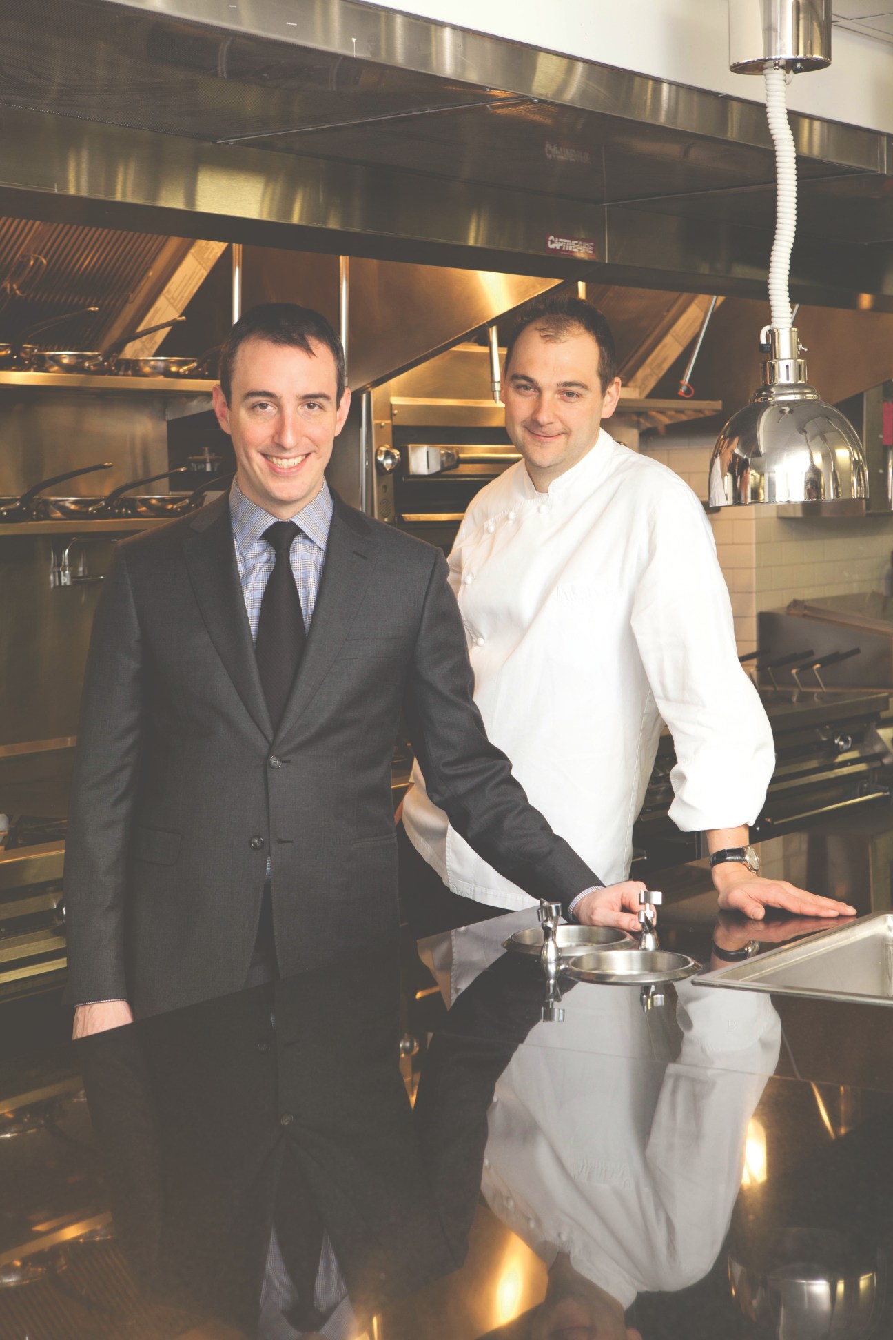 Daniel Humm and Will Guidara stand together in a professional kitchen at Eleven Madison Park restaurant.
