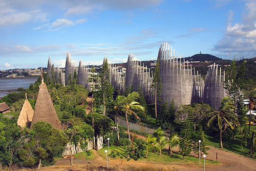 Aerial view of Jean-Marie Tjibaou Cultural Centre with distinctive slatted wooden structures and surrounding landscape in Nouméa, New Caledonia.