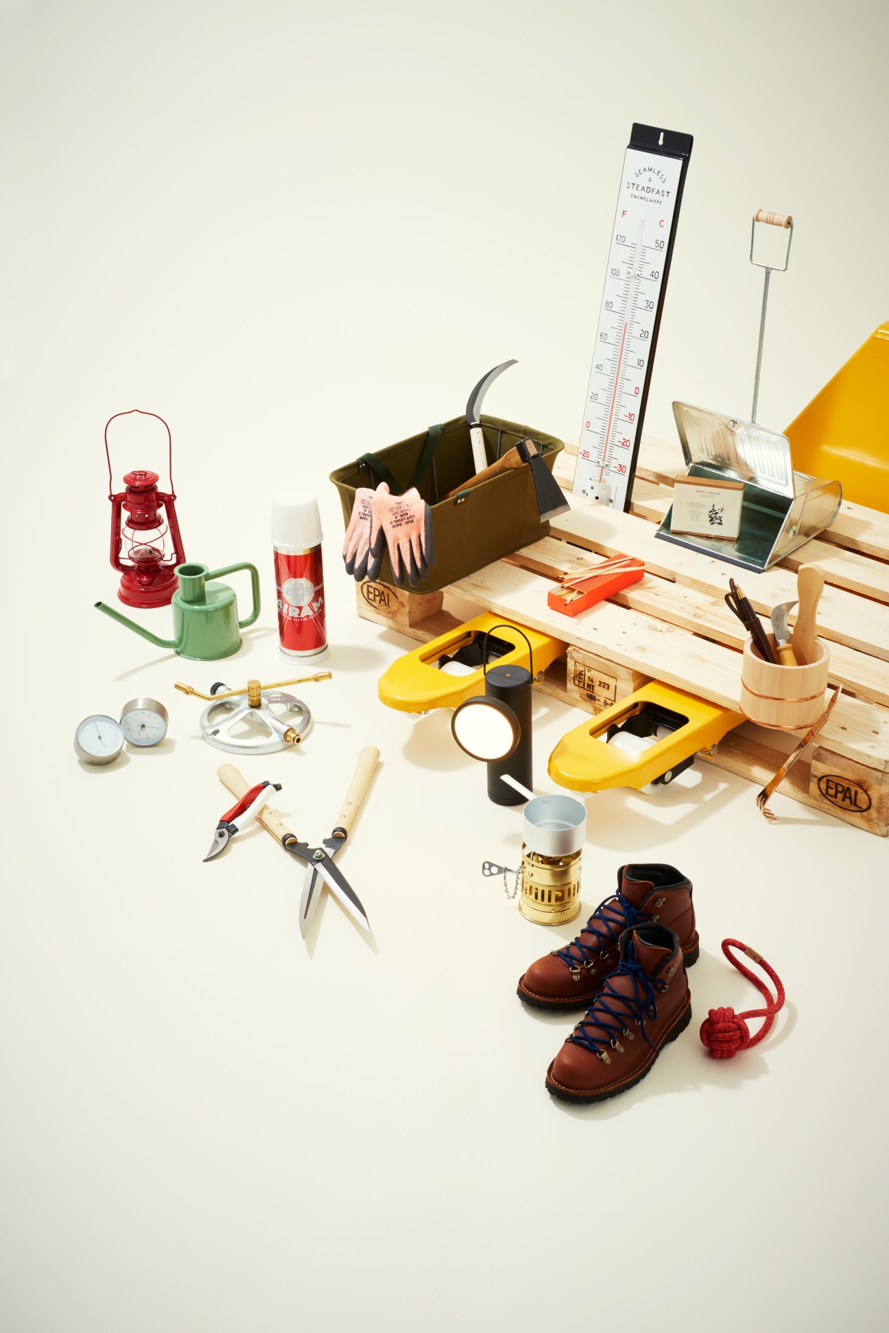 Garden tools and accessories including boots, lantern, thermometer, secateurs, watering can, and wooden crates.