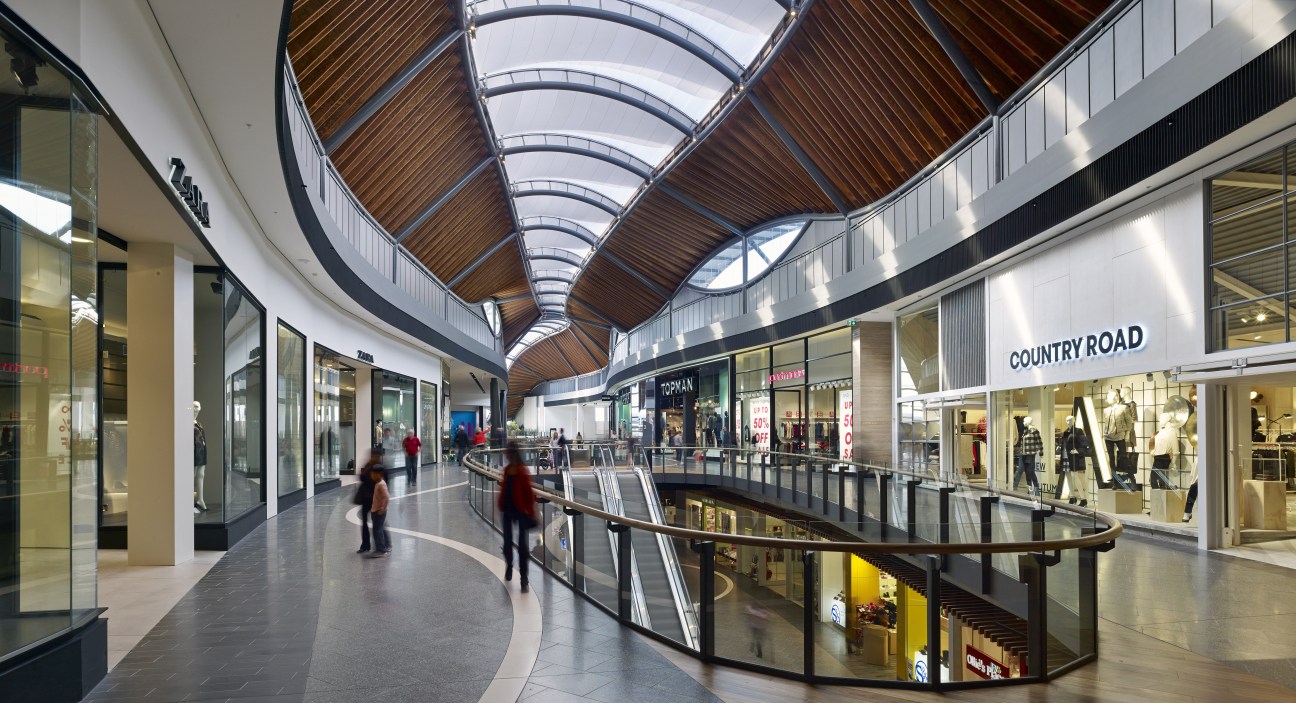 Interior of Highpoint shopping centre with curved skylights, retail storefronts and multiple levels.
