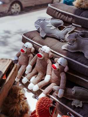 Dog toys and accessories including plush toys and knitted items displayed on shelves.