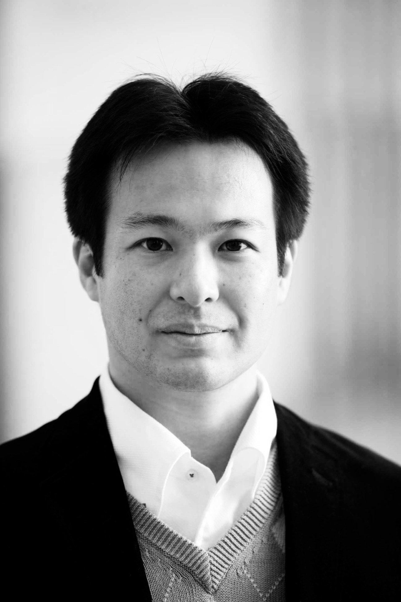 Black and white headshot of Satoshi Ikeuchi, Associate Professor at the University of Tokyo, wearing a dark blazer and white shirt.