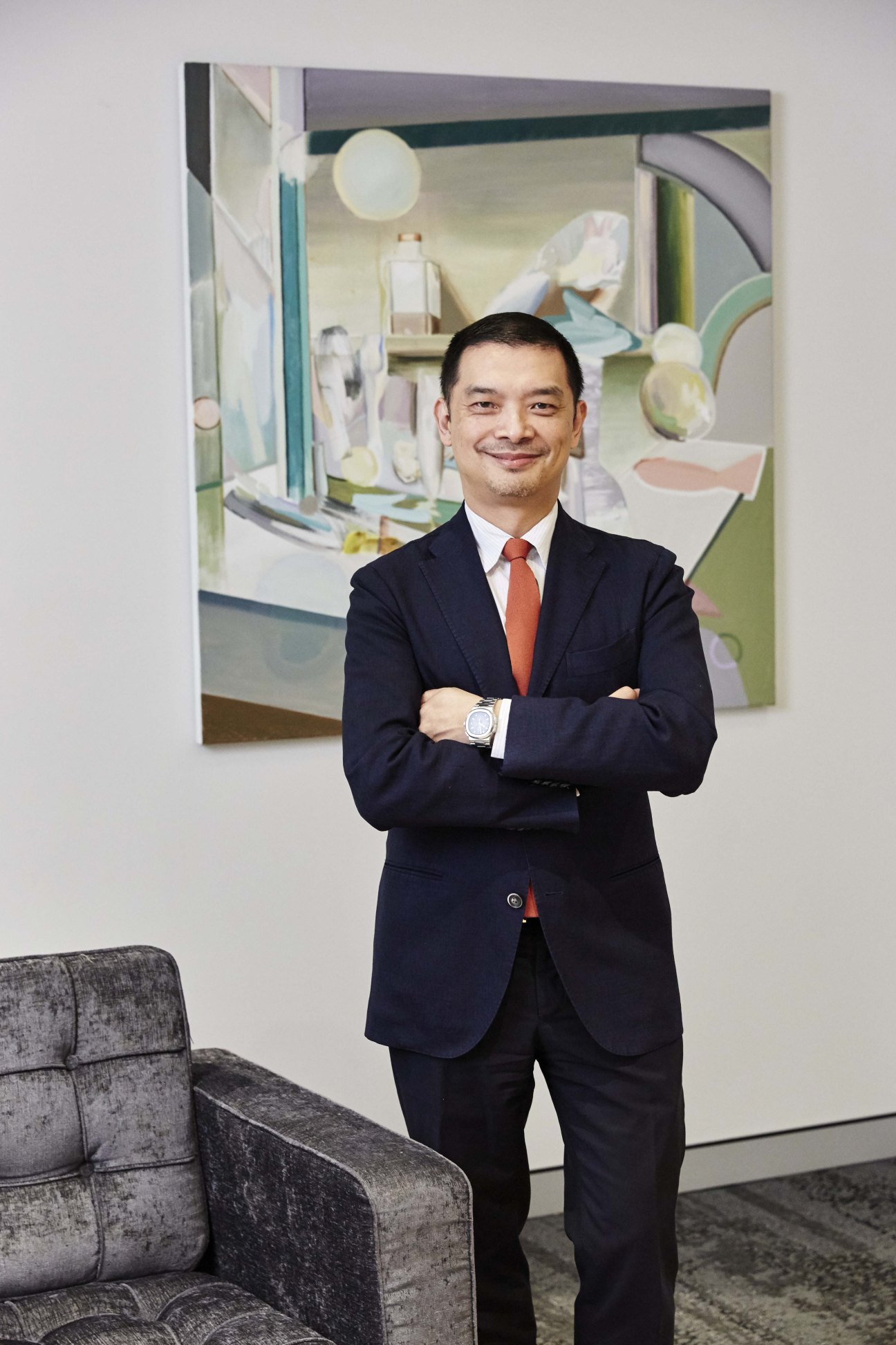 Dick Quan, Sydney-based art collector and medical doctor, standing with arms crossed in front of contemporary artwork.