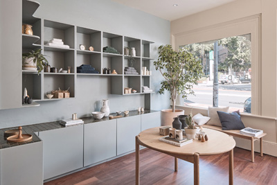 Interior of In Bed Store in Sydney showing shelving, seating area and display of bedding and homeware products.