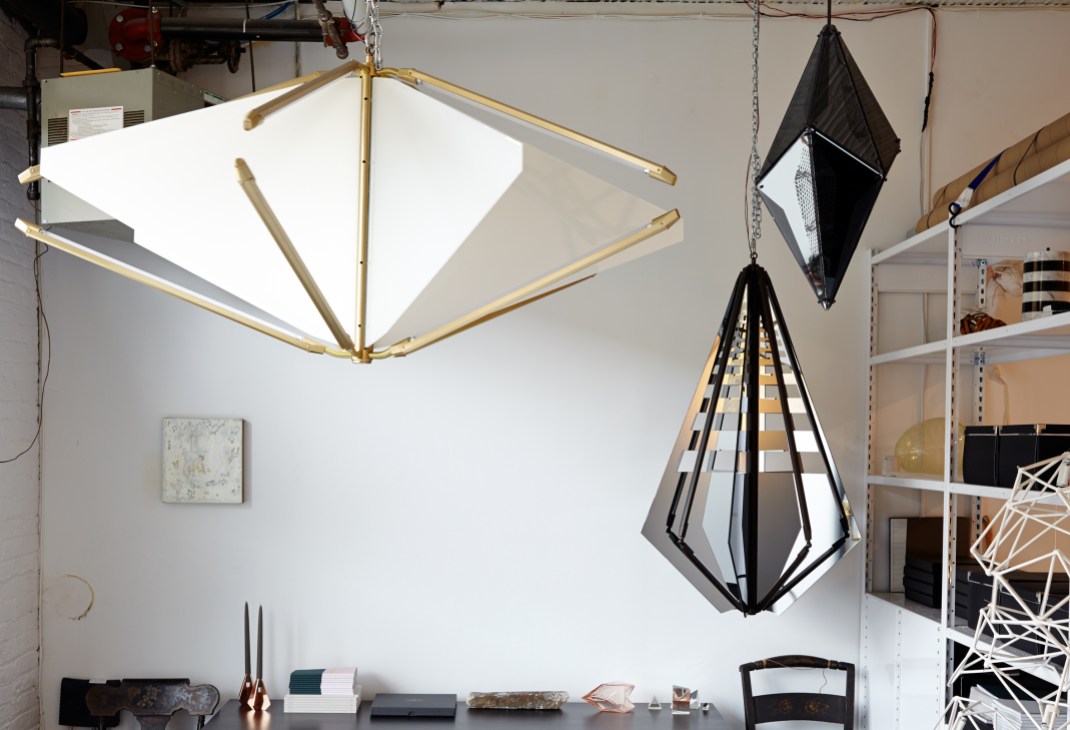 Bec Brittain's studio workspace displaying pendant lights with brass and geometric black designs.
