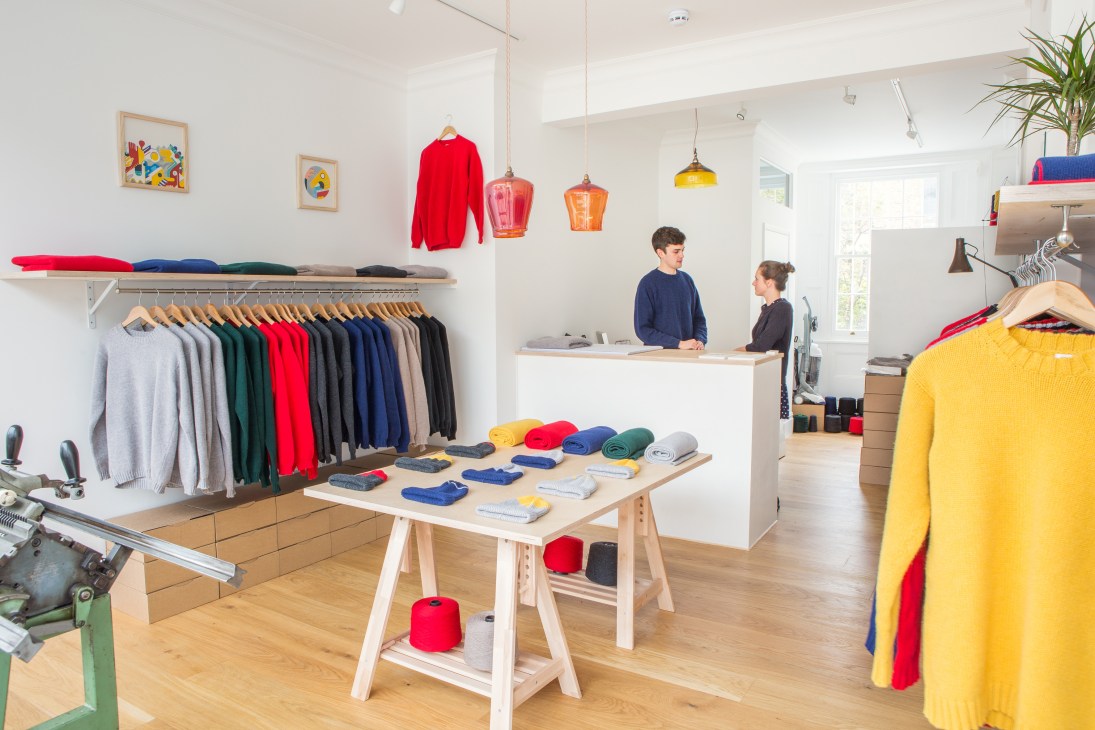 Country of Origin knitwear shop interior with colorful sweaters on display and knitting machines visible.