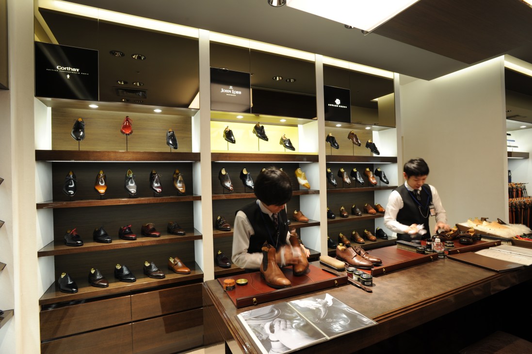 Interior of Isetan men's shop at Haneda Airport showing shoe displays with designer footwear.