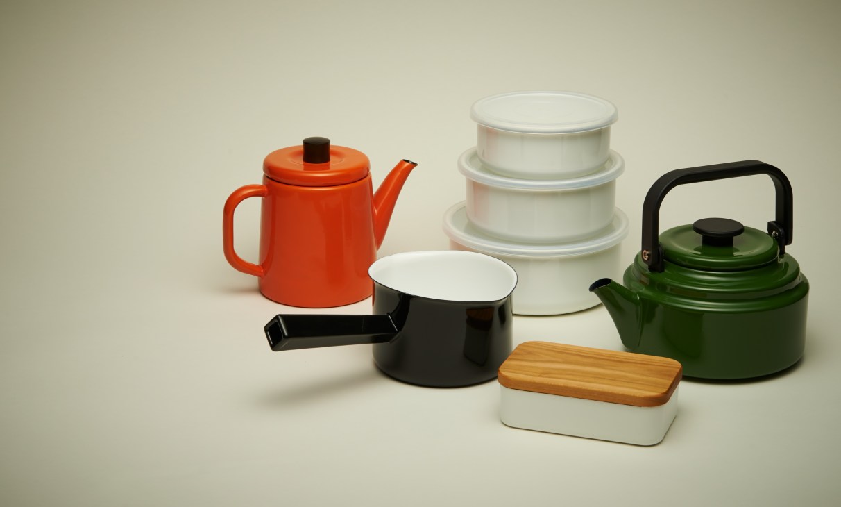 Noda Horo enamelware products including red and green kettles, white containers, black pan, and butter dish with wooden lid.