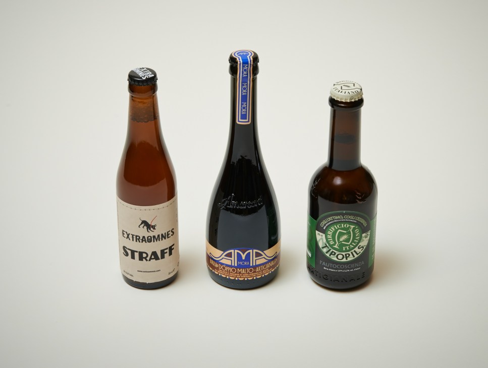 Three Italian craft beer bottles: Extraomnes Straff, Amarcord AMA Mora, and Birrificio Italiano Tipopils.