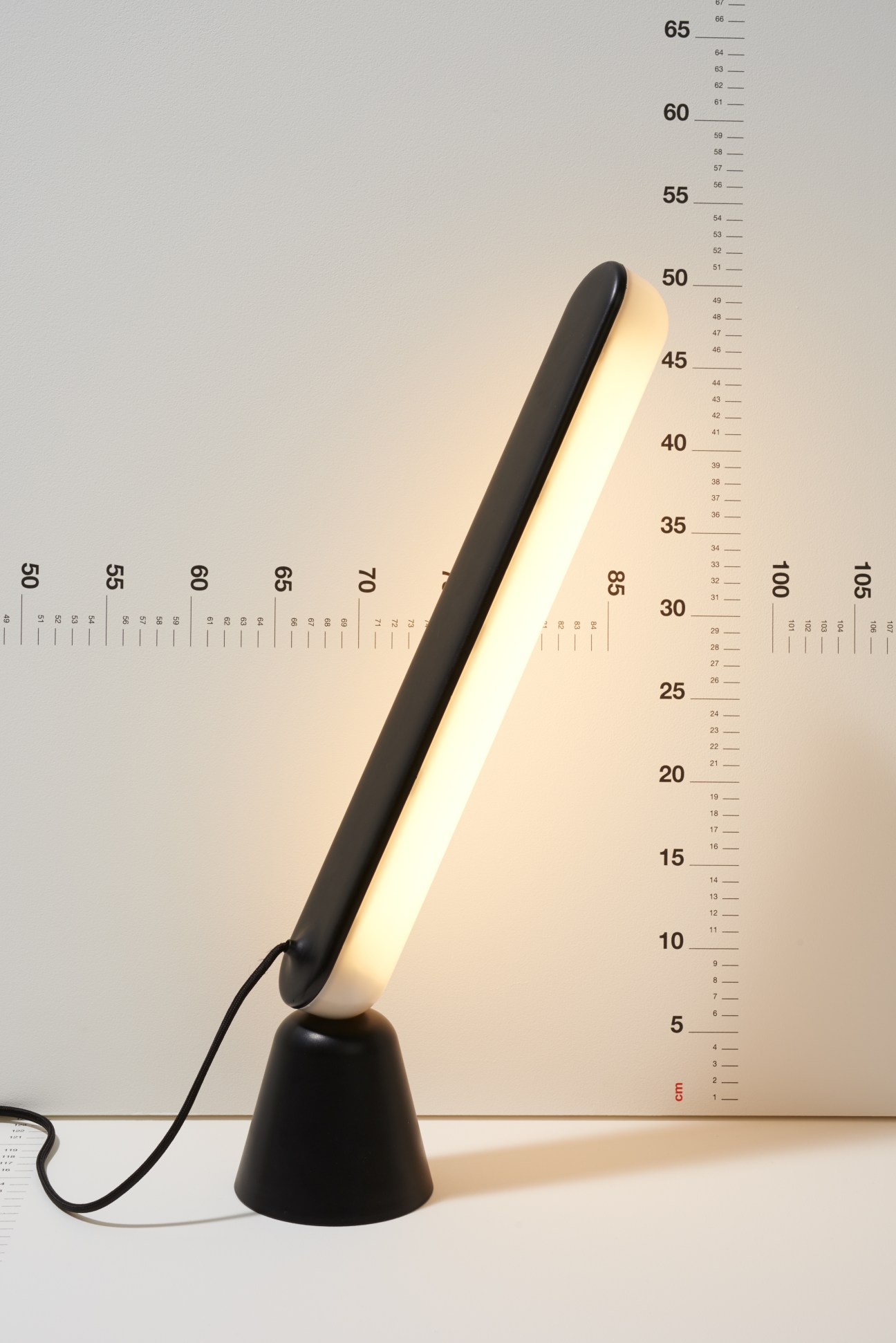 Acrobat lamp by Marc Venot for Normann Copenhagen with adjustable black arm and cream base.