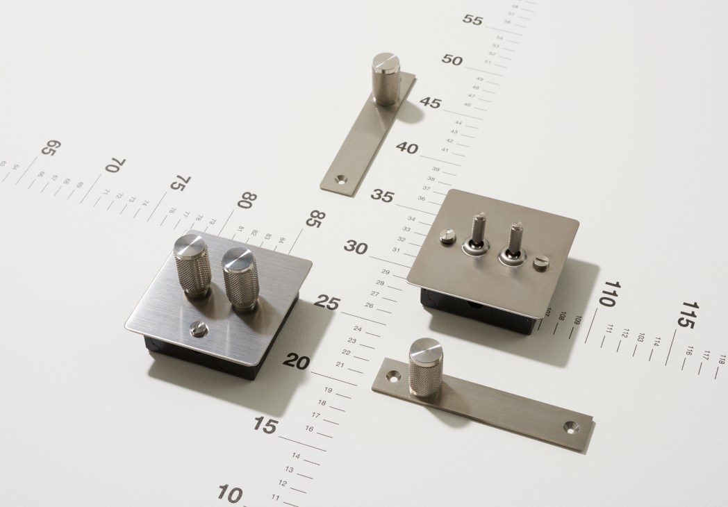 Buster + Punch switches, dimmers and handles displayed on a measuring scale.