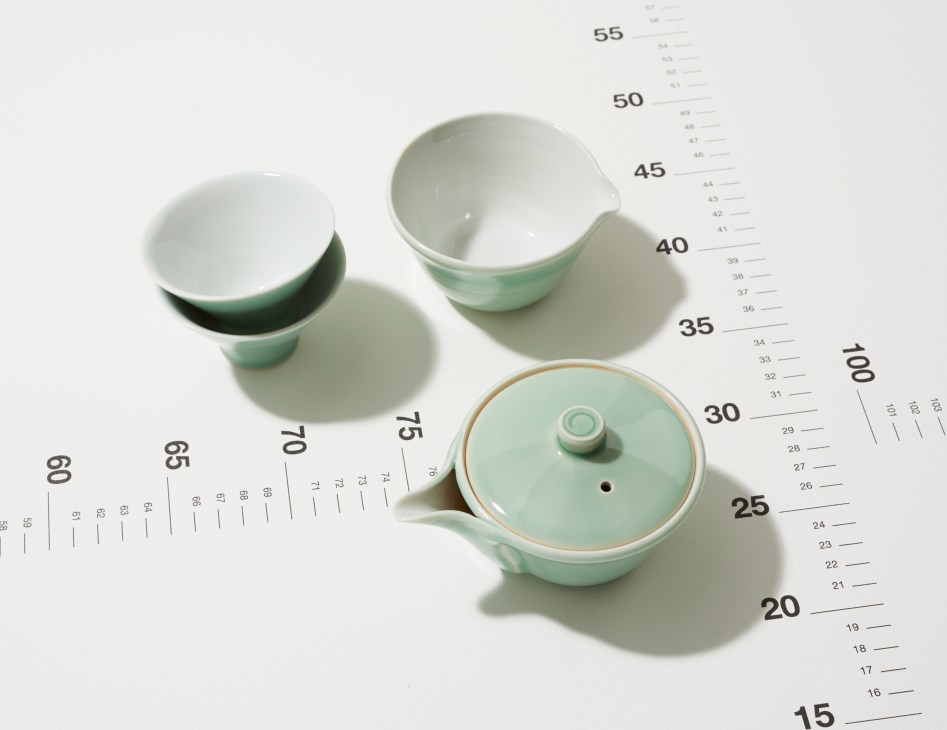 Reversible coffee table and serving tray by Hans J Wegner for Carl Hansen & Søn with black and oak sides displayed with bowls on measurement scale.