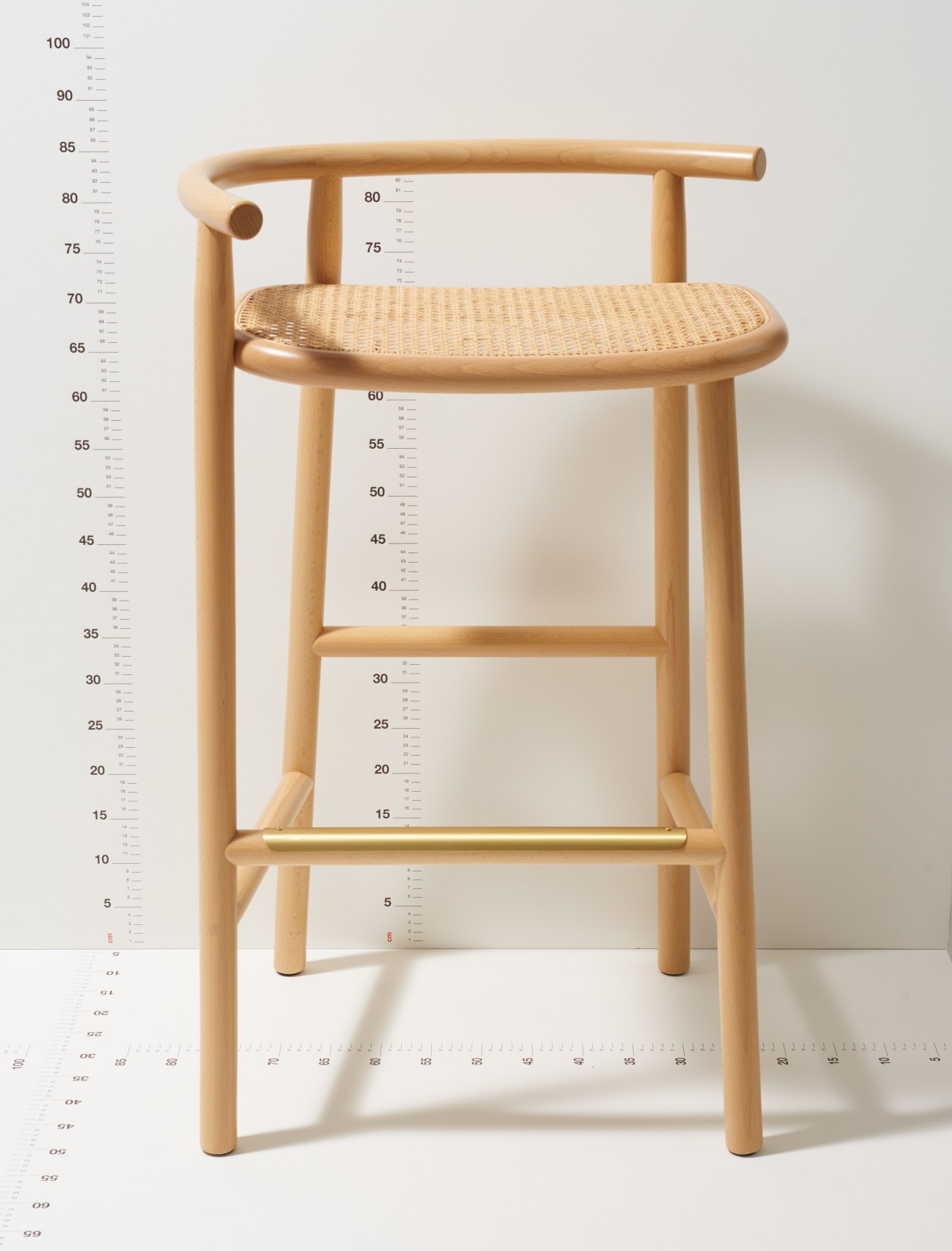 Single-curve barstool by Nendo for Gebrüder Thonet Vienna with light wood frame and woven seat.