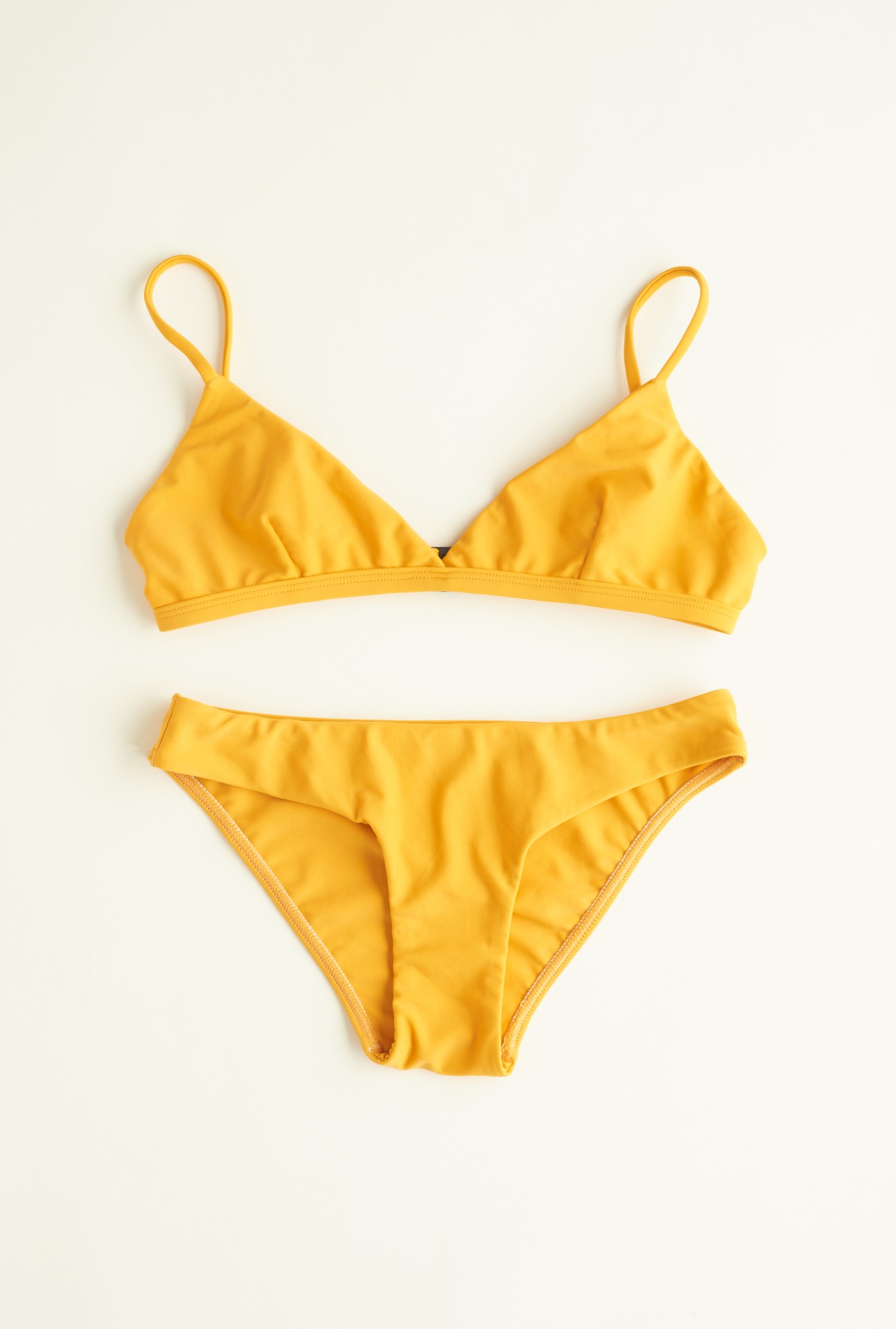 Yellow two-piece swimsuit displayed against a neutral background