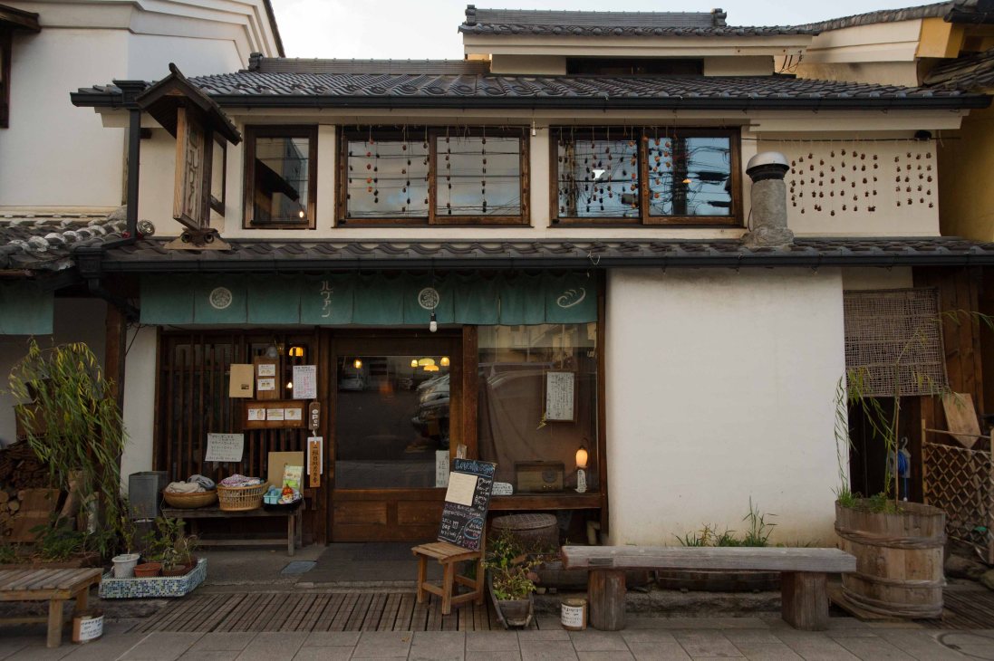 Traditional Japanese wooden storefront of Levain bakery with dark timber framing, large windows, and decorative hanging ornaments.