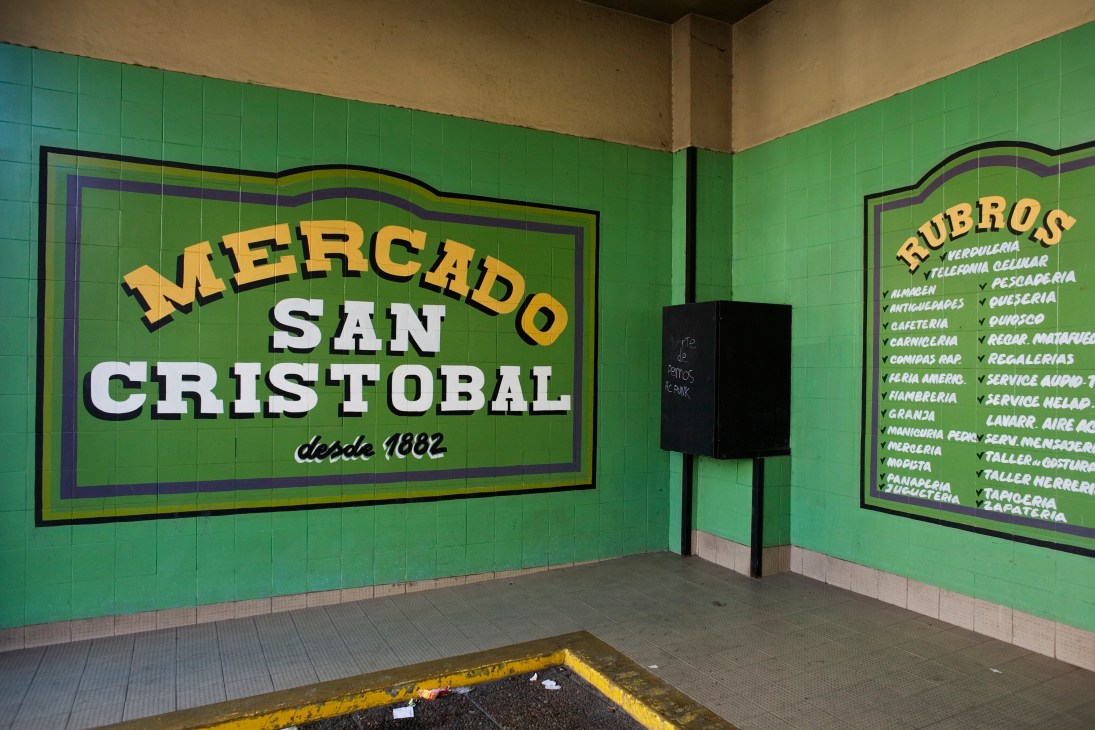 Mercado San Cristóbal market entrance with bright green tiled walls and vintage yellow lettering.