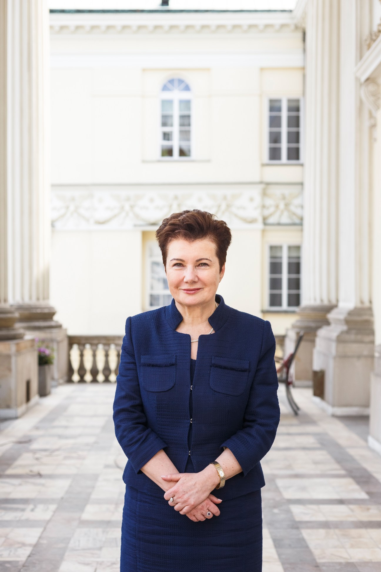 Hanna Gronkiewicz-Waltz, Mayor of Warsaw, standing in front of a neoclassical building with white columns.
