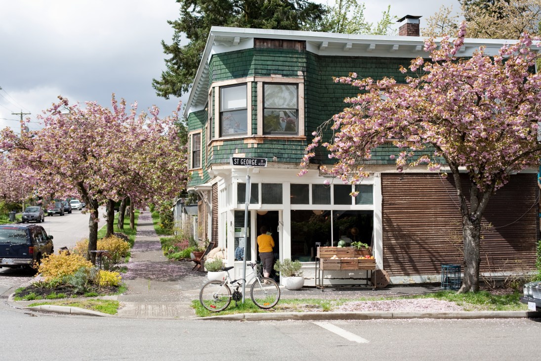 Le Marché St George café in a 100-year-old corner house with blooming cherry trees on Main Street, Vancouver.