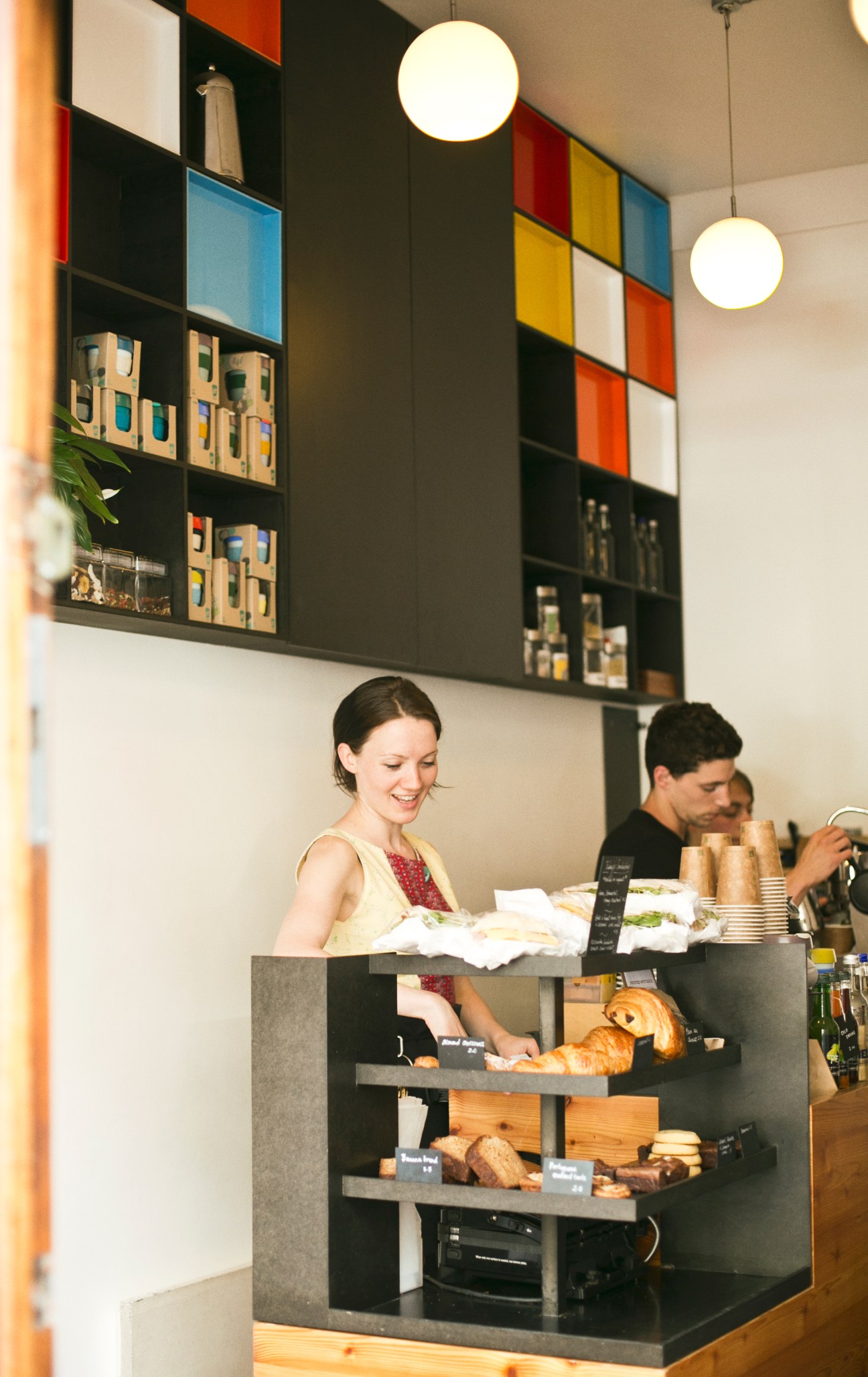 Woman smiling behind counter at The Espresso Room coffee shop in Bloomsbury, London.