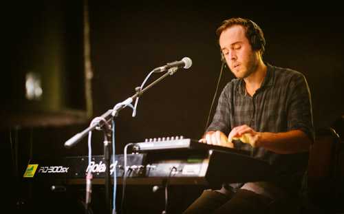 Bristol-based producer and composer LTO performing with keyboard and microphone on stage.