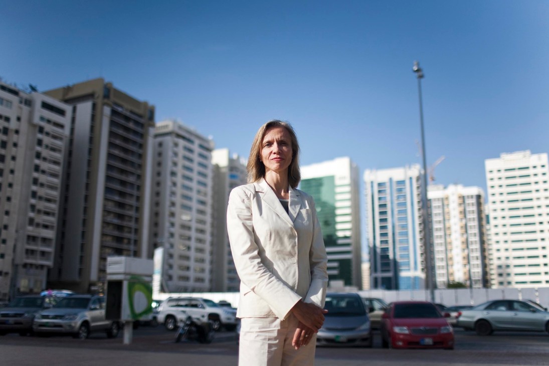 Mariët Westermann, Provost of NYU Abu Dhabi, standing in front of modern high-rise buildings in Abu Dhabi.