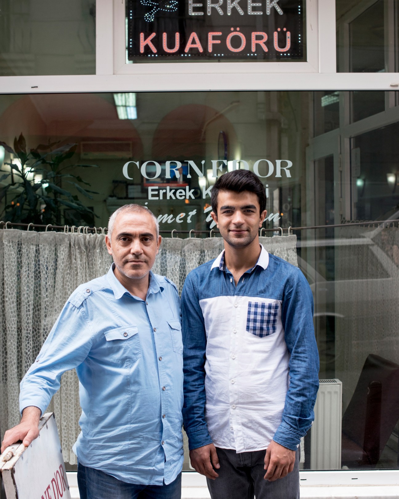 Huseyin Akbay and apprentice Aydin Simsek stand outside Cornedor barbershop in Istanbul.