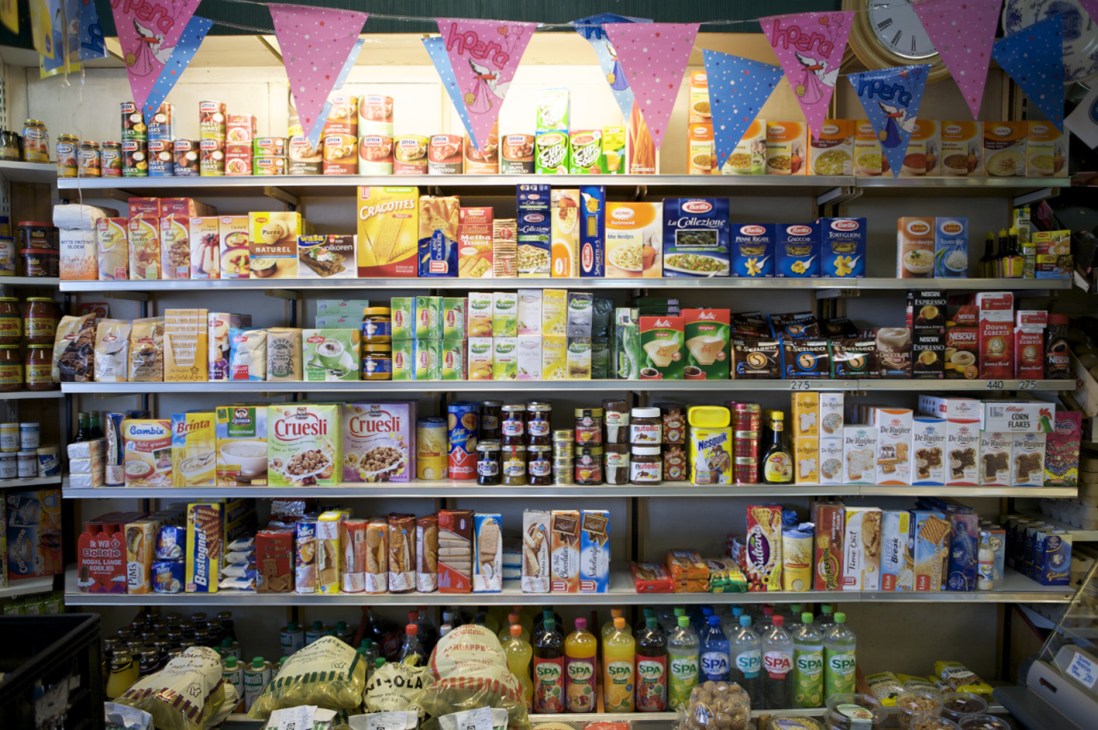 Shelves of packaged groceries and food products at Place des Légumes greengrocer.