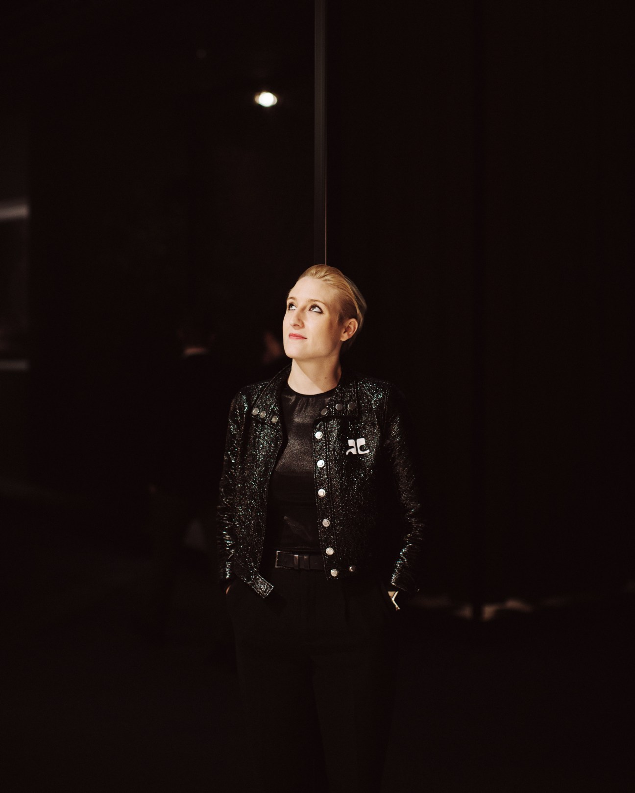 Victoria Wilmotte, a Parisian designer, wearing a sparkly black jacket against a dark background.
