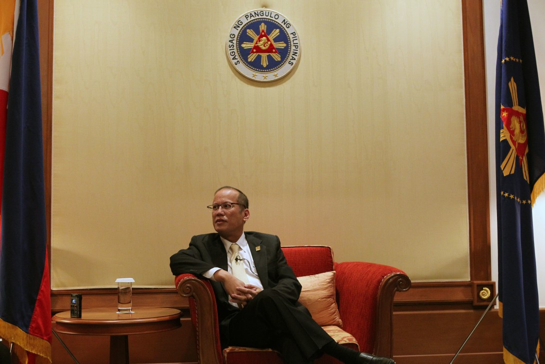 Benigno Aquino III seated in an armchair beneath the presidential seal in Malacañang Palace.