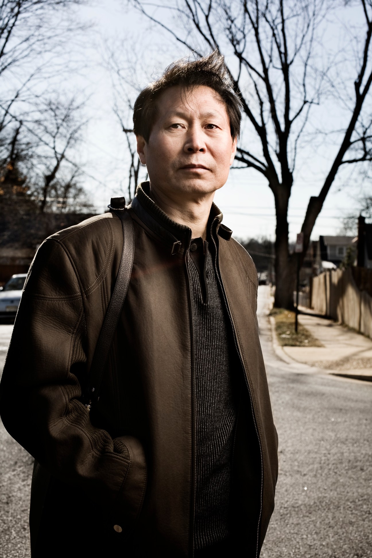 Portrait of Li Xuejiang, Washington bureau chief for People's Daily China, standing outdoors wearing a brown jacket.