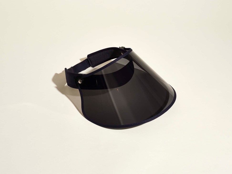 Black sun visor with adjustable headband and tinted face shield against neutral background.