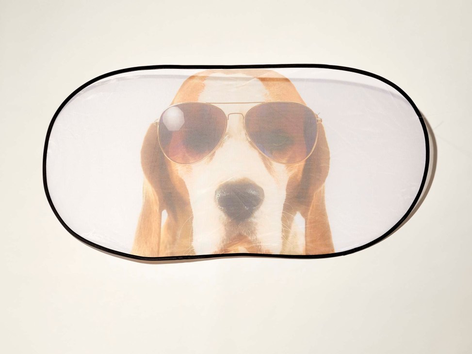 Rear window car shade featuring a dog wearing sunglasses printed on translucent material.