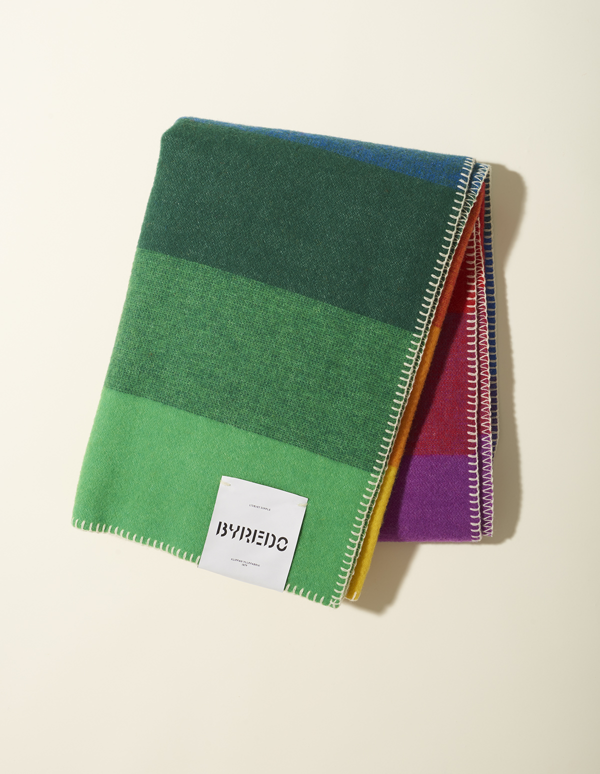 Rainbow-hued merino and lambswool blanket by Byredo with whipstitched edges