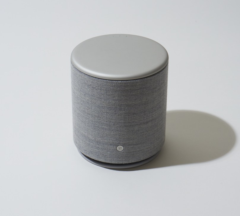 Bang & Olufsen Beoplay M5 cylindrical speaker with aluminum top and fabric body.