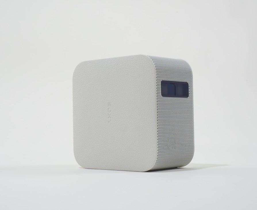 White Sony portable projector with mesh speaker grille and display screen.