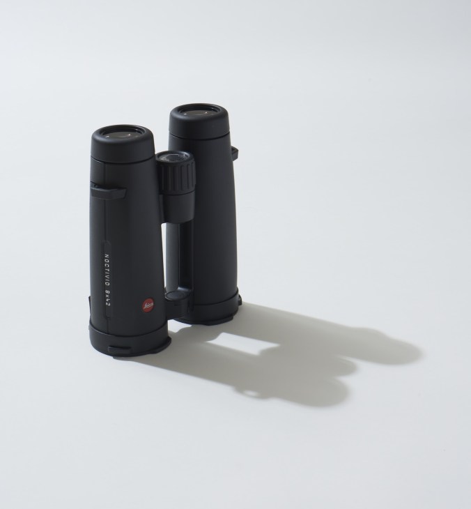 Leica Noctivid binoculars in black with olive-green cordura carrying strap on white background.